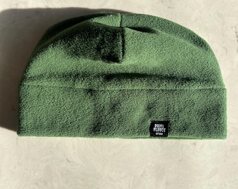 May include: A green fleece beanie with a black label that says "Dome Fleece" on it.