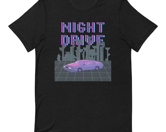 Pode incluir: Camiseta preta com um gráfico pixelado de um carro dirigindo à noite com o texto "NIGHT DRIVE" em uma fonte pixelada.