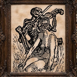 May include: A framed black and white cross-stitch artwork depicts a skeleton playing a violin above a person. The artwork is in a dark brown ornate frame. A skull rests on a stone surface to the right of the frame.