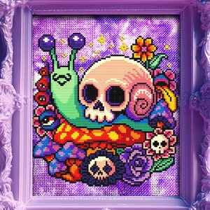 Puede incluir: Una obra de arte en punto de cruz enmarcada que presenta una calavera con una concha de caracol, rodeada de coloridas setas, flores y otros elementos caprichosos. El marco es de color lila claro con detalles ornamentados.