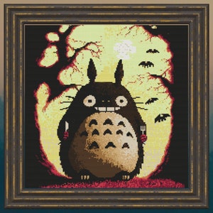 May include: A cross-stitch pattern of Totoro, a character from the animated film My Neighbor Totoro, holding a knife and fork in front of a full moon. The background is a dark forest with trees and bats.
