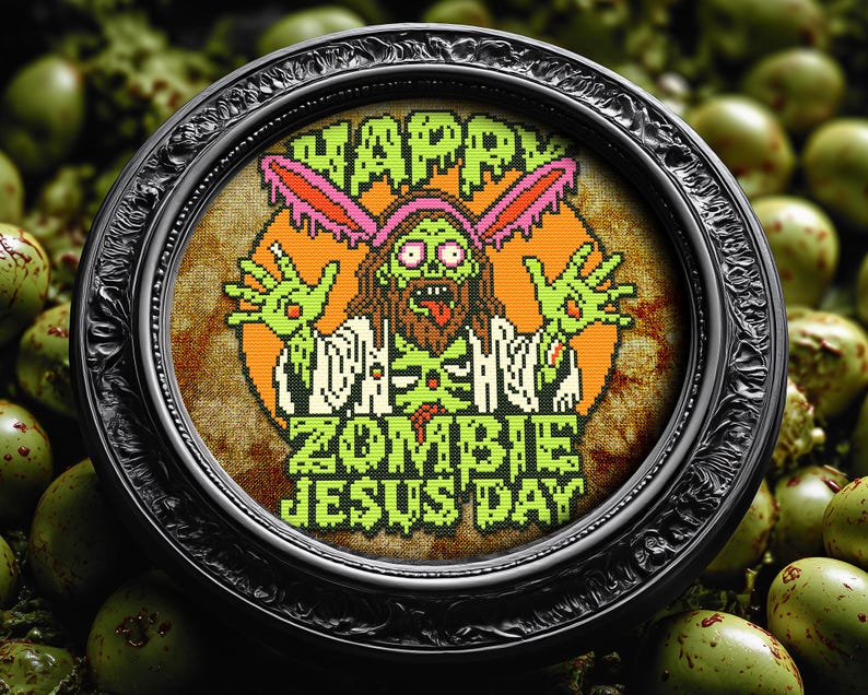 May include: A black framed embroidery hoop with a colorful cross-stitch design. The design features a zombie Jesus with bunny ears and the text "Happy Zombie Jesus Day".