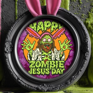 May include: A black framed embroidery hoop with a purple background and a green zombie Jesus wearing a bunny ear headband. The text reads "Happy Zombie Jesus Day".