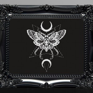 Può includere: Ricamo in bianco e nero di una falena con lune crescenti e motivi geometrici in una cornice nera.