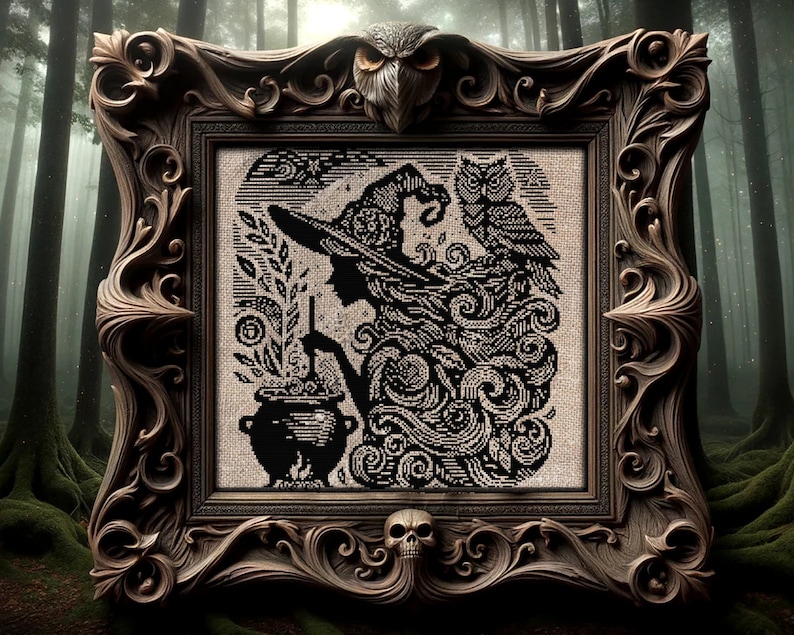 Puede incluir: Un bordado enmarcado que representa a una bruja con un caldero, un b&uacute;ho y detalles arremolinados. El dise&ntilde;o en blanco y negro est&aacute; enmarcado en un marco de madera marr&oacute;n ornamentado, con una calavera en la parte inferior y un b&uacute;ho en la parte superior.