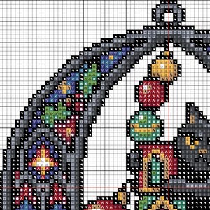 Op de afbeelding: Een kruissteekpatroon met een kleurrijk, geometrisch ontwerp. Het patroon bevat verschillende vormen en kleuren, waaronder rood, groen, blauw en geel, gerangschikt in een raster. Het ontwerp lijkt een decoratief element te zijn.