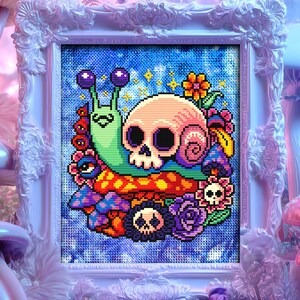 Puede incluir: Un punto de cruz enmarcado con un dise&ntilde;o caprichoso de una calavera, un caracol y setas. La calavera es rosa, el caracol es verde y las setas son de varios colores. El fondo es azul y el marco es blanco.