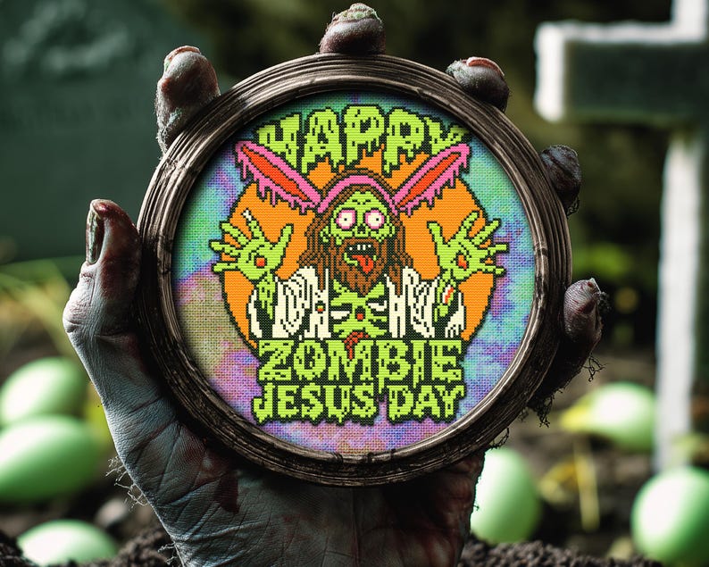 May include: A green zombie Jesus with bunny ears holding a sign that says "Happy Zombie Jesus Day" in a cross-stitch style embroidery hoop.