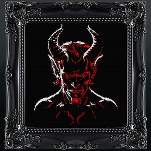 May include: A framed cross-stitch portrait of a horned demon with red and white details against a black background. The ornate black frame adds a gothic aesthetic to the artwork. The image is a close-up of the demon's face.