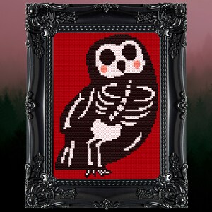 May include: A black and white cross-stitch embroidery of a skeleton owl with pink cheeks on a red background. The owl is framed in a black ornate frame.