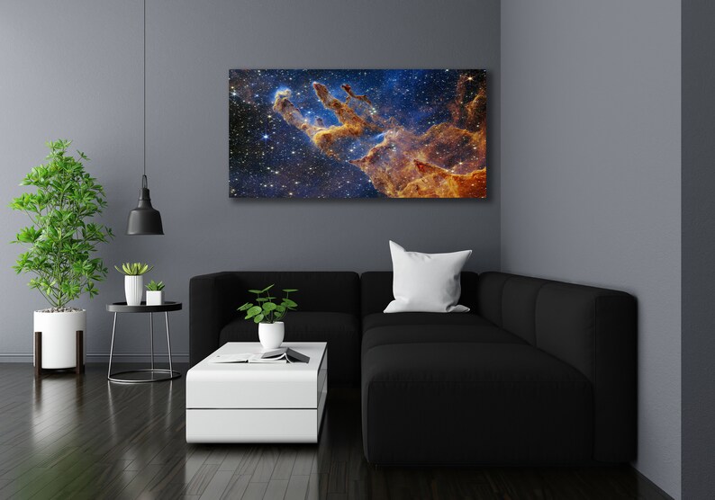 K&ouml;nnte beinhalten: Ein schwarzes Ecksofa mit einem wei&szlig;en Kissen vor einer Wand mit einem gro&szlig;en Druck einer Nebel in Blaut&ouml;nen, Orange und Gelb.