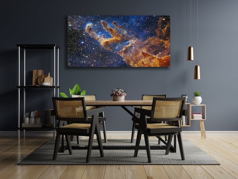 K&ouml;nnte beinhalten: Ein Esszimmer mit einer dunkelblauen Wand und einem gro&szlig;en Leinwanddruck einer Nebel in Blaut&ouml;nen, Orange und Gelb. Der Druck h&auml;ngt &uuml;ber einem Holztisch mit vier schwarzen St&uuml;hlen. Die St&uuml;hle haben geflochtene Korbsitze und -lehnen. Es gibt einen kleinen Holz-Beistelltisch mit einer Topfpflanze darauf.