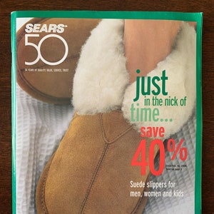 Könnte beinhalten: Eine Sears-Anzeige zum 50-jährigen Jubiläum mit einem Paar braunen Wildlederschuhen mit weißem Pelzbesatz. Der Anzeigentext lautet: "Gerade rechtzeitig... sparen Sie 40 % bis zum 10. Februar 2004. Auf Seite 2 erhältlich. Wildlederschuhe für Männer, Frauen und Kinder."