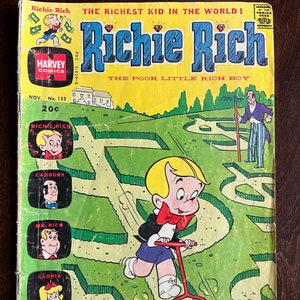 May include: A comic book cover featuring Richie Rich, a cartoon character known for his wealth, mowing the lawn with a red lawnmower. The cover is green and yellow with the title "Richie Rich" in large red letters. The text "The Richest Kid in the World!" and "The Poor Little Rich Boy" are also featured on the cover.