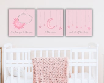 May include: Three pink canvas prints with watercolor illustrations of the sun, moon, and stars. The text on the prints reads "We love you to the sun", "to the moon", and "and all of the stars".