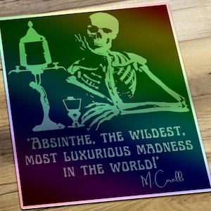 May include: A green and black iridescent metal sign with a skeleton holding a glass of absinthe. The sign features the quote 'Absinthe, the wildest, most luxurious madness in the world!' attributed to M.Cnelli.