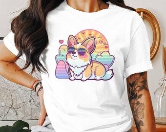 May include: White t-shirt featuring a cartoon corgi wearing sunglasses against a rainbow background. The corgi is surrounded by hearts and clouds.