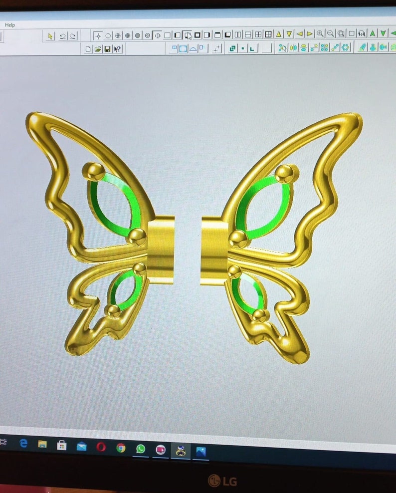 May include: A gold butterfly design with green accents. The butterfly is split into two pieces, with each piece having a wing.