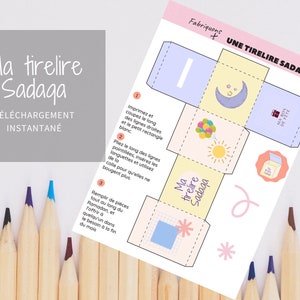 Può includere: Modello stampabile per una scatola di carta colorata con le parole "Ma tirelire Sadaga" e istruzioni per il montaggio. La scatola è decorata con una luna crescente, stelle, un sole e palloncini.