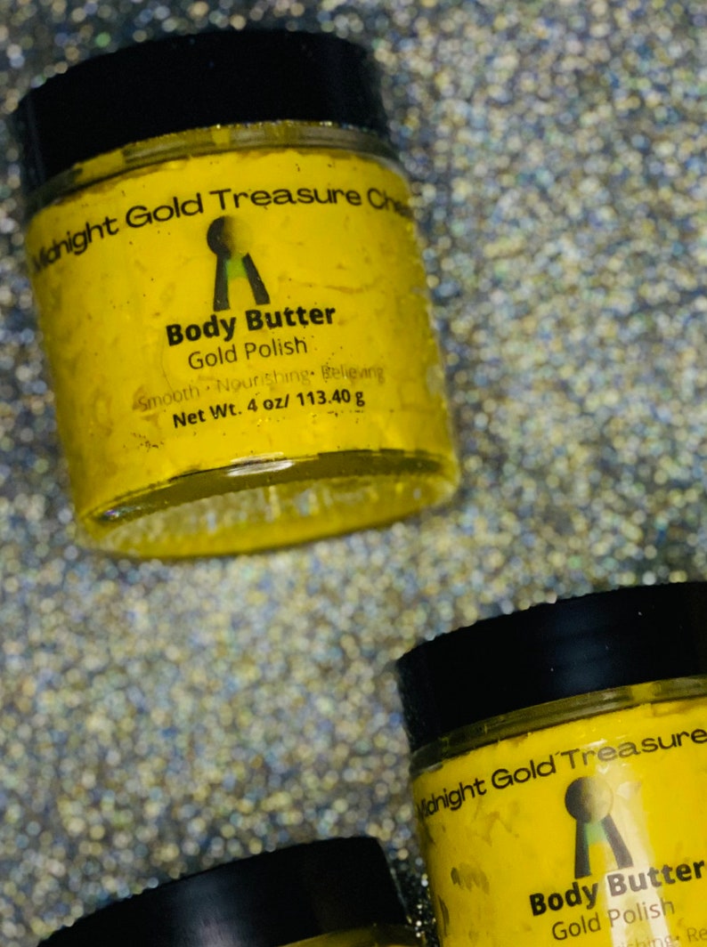 Op de afbeelding: Twee gele potten met body butter en zwarte deksels. De potten zijn gelabeld met "Midnight Gold Treasure" en "Body Butter Gold Polish". De potten staan op een glinsterende achtergrond.