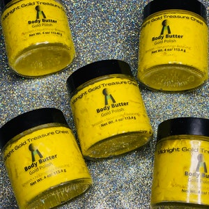 May include: Five yellow jars of body butter with black lids. Each jar has a gold key logo and the text "Midnight Gold Treasure Chest" and "Body Butter Gold Polish" with the net weight of 4 oz/113.4 g.