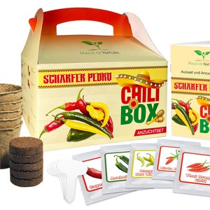 Könnte beinhalten: Ein Chili-Anzuchtset in einer braunen Box mit rotem Griff. Die Box trägt den Text "SCHARFER PEDRO CHILI BOX ANZUCHTSET". Das Set enthält Torftabletten, Saatgutbeutel und kleine Töpfe. Die Saatgutbeutel zeigen Bilder von verschiedenen Chili-Sorten und den Text "Cayenne", "Anshot", "Hot Wax", "Birds Eye" und "Thai Dragon Chili".