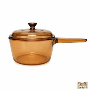 May include: A translucent amber-coloured glass saucepan with a matching lid and a long, integrated handle. The cookware features a smooth, rounded body and a circular knob on the centre of the lid. The glass is clear and uniform in its warm brown tone.