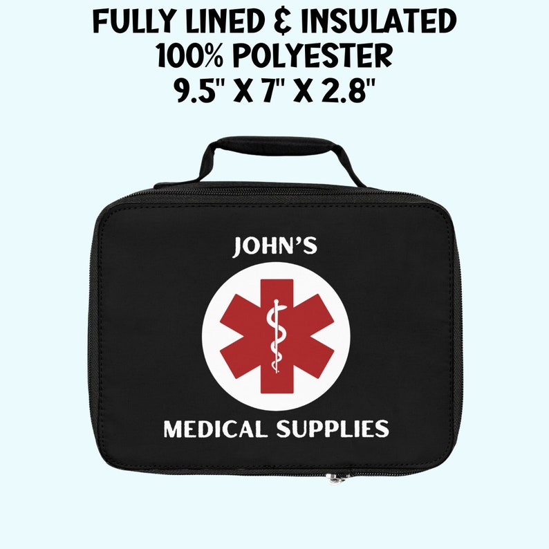 Op de afbeelding: Zwarte medische tas met een rood medisch symbool en de tekst "JOHN'S MEDICAL SUPPLIES". De tas is 9,5 inch bij 7 inch bij 2,8 inch.