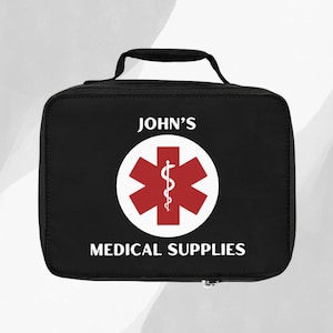 Op de afbeelding: Zwarte medische tas met een witte rits, een rood ster-van-leven-symbool en de tekst "JOHN'S MEDICAL SUPPLIES".