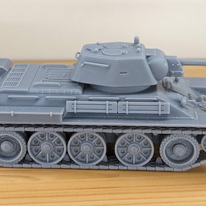Può includere: Un modello grigio di carro armato con una canna lunga e cingoli dettagliati. Il carro armato in miniatura ha una torretta ed è probabilmente una replica di un veicolo militare storico. Il modello è esposto su una superficie di legno.