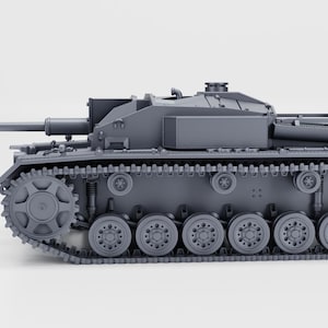 Puede incluir: Maqueta gris de un tanque con orugas, ruedas y cañón detallados. El tanque tiene una torreta cuadrada y está sobre un fondo liso. El modelo es una réplica detallada de un vehículo militar.