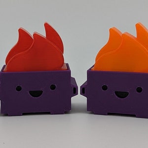 May include: Four purple and orange 3D printed figurines of a trash can with a smiling face and flames on top.