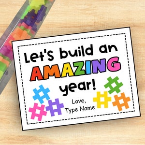 May include: A printable card with the text "Let's build an AMAZING year!" in rainbow colors. The card features colorful hashtag symbols and a space to add a name.