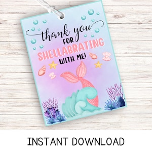 May include: A pink mermaid tail with a blue wave and seashells on a purple and blue background. The text "Thank you for Shellabrating with me!" is written on the tag.