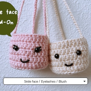 May include: Two small crocheted bags with smiling faces. The bag on the left is pink and the bag on the right is beige. Both bags have black eyes and a black smile. The text "Smile face Add-On" is written in green on a white background. The text "Smile face / Eyelashes / Blush" is written in black on a white background.