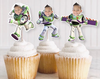May include: Three cupcakes with white frosting topped with edible images of a cartoon character dressed as a space ranger. The character has a child's face in the image.