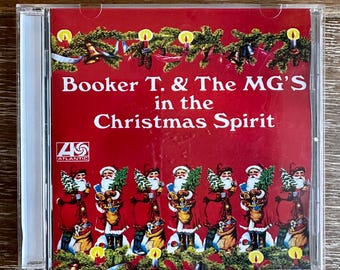 May include: A red CD case with a picture of Santa Claus and the text "Booker T. & The MG's in the Christmas Spirit" on the front. The CD case is from the Atlantic Records label.
