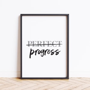 May include: Black and white framed print with the text "PERFECT" crossed out and "progress" written in cursive below.