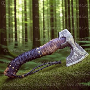May include: A handcrafted axe with a wooden handle and a metal blade. The handle is wrapped in dark brown leather with brass studs. The blade features intricate engraved designs. A black cord is attached to the handle. The axe is displayed on a mossy surface.