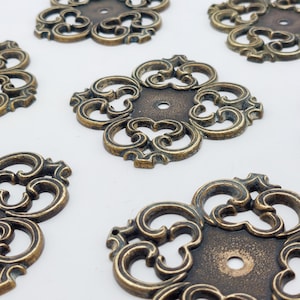 May include: A white ceramic mug with a black handle and the text "But First, Coffee" in a bold, black font. The mug is set against a blurred background, suggesting a cozy setting. The mug appears to be approximately 4 inches tall.