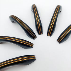 May include: A set of three ceramic mugs with a speckled, matte finish. The mugs are in shades of cream, light gray, and dark gray. Each mug has a simple, minimalist design and a rounded handle.