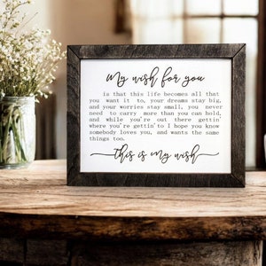 May include: A framed sign with a black wood frame and a white background. The sign has a handwritten message that reads "My wish for you is that this life becomes all that you want it to, your dreams stay big, and your worries stay small, you never need to carry more than you can hold, and while you're out there gettin' where you're gettin' to I hope you know somebody loves you, and wants the same things too. This is my wish."