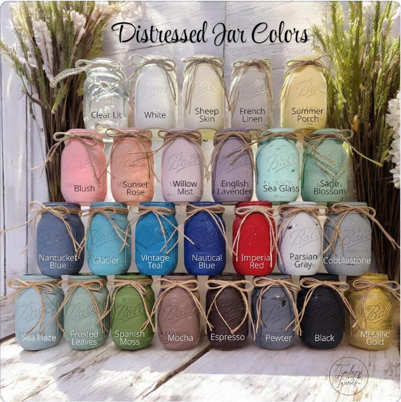May include: A collection of glass mason jars in various colors, each tied with a jute twine bow. The jars are labeled with names like Clear Lit, White, Sheep Skin, French Linen, Summer Porch, Blush, Sunset Rose, Willow Mist, English Lavender, Sea Glass, Sage Blossom, Nantucket Blue, Glacier, Vintage Teal, Nautical Blue, Imperial Red, Parsian Gray, Cobblestone, Sea Haze, Frosted Leaves, Spanish Moss, Mocha, Espresso, Pewter, Black, and Metallic Gold.