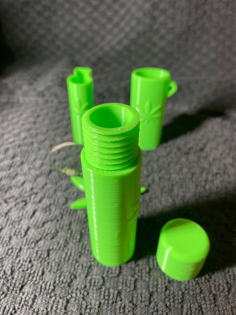 May include: A set of three lime green 3D printed containers with a leaf design. The containers are cylindrical and have a screw-on lid.