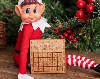 May include: A wooden countdown calendar with the text "Countdown to Christmas with me" and numbers 1 through 24. A red and white striped elf doll is holding the calendar.