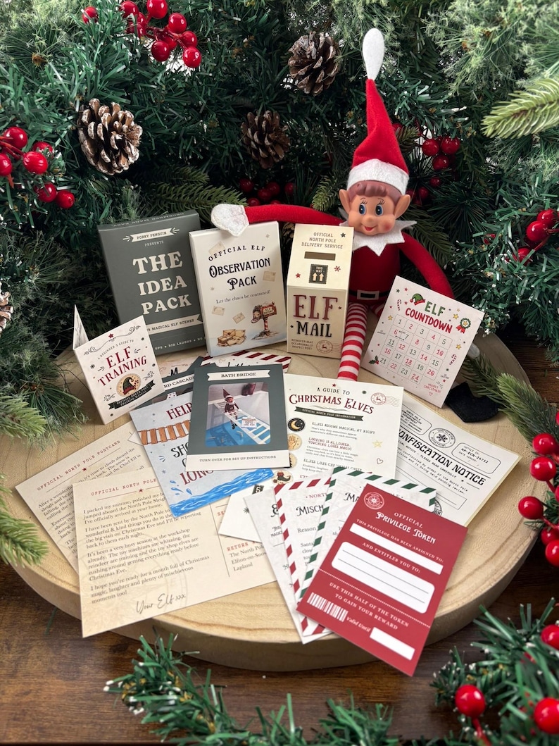 Pu&ograve; includere: Una bambola elfo di Natale con cappello rosso e gambe a righe siede dietro una collezione di articoli di carta stampata, tra cui un pacchetto di osservazione ufficiale, una cassetta delle lettere, un calendario e varie carte natalizie.