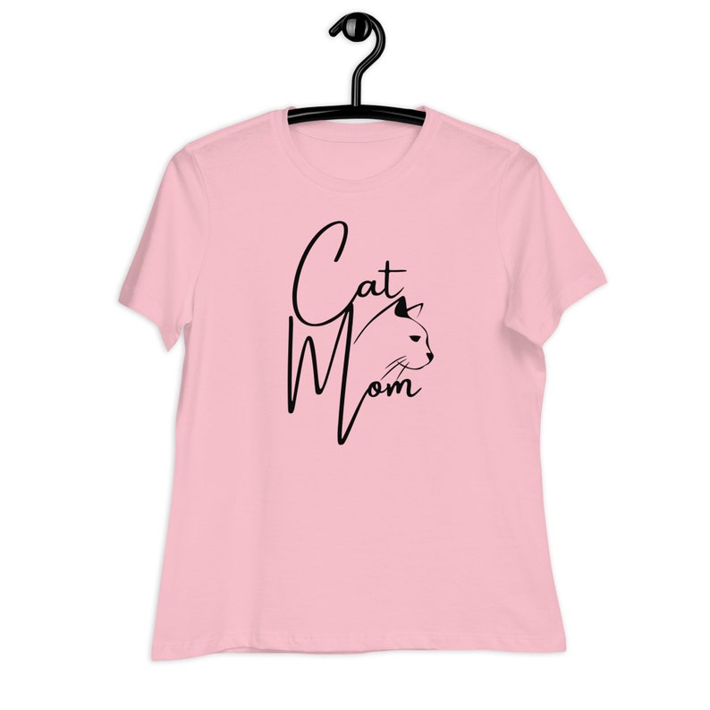 May include: Pink t-shirt with black text that says "Cat Mom" and a black silhouette of a cat's head.