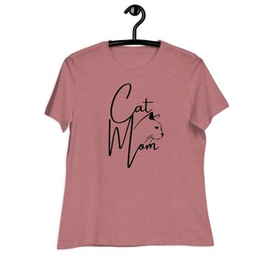 May include: A heather pink t-shirt with a black graphic that says "Cat Mom" with a stylized cat head silhouette.