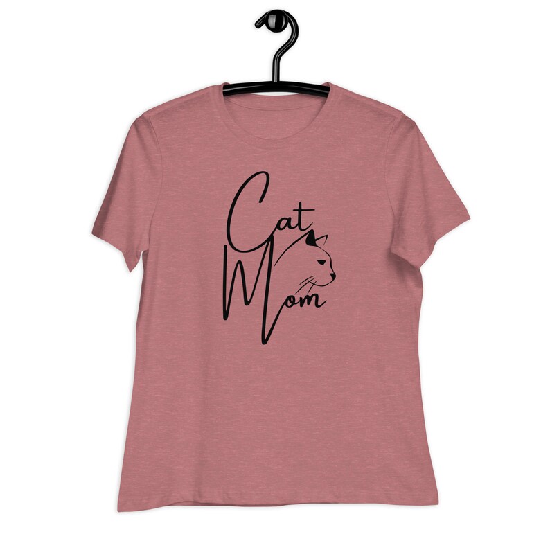May include: A heather pink t-shirt with a black graphic that says "Cat Mom" with a stylized cat head silhouette.