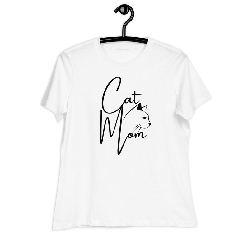 May include: White t-shirt with black text that reads "Cat Mom" and a black silhouette of a cat's head.